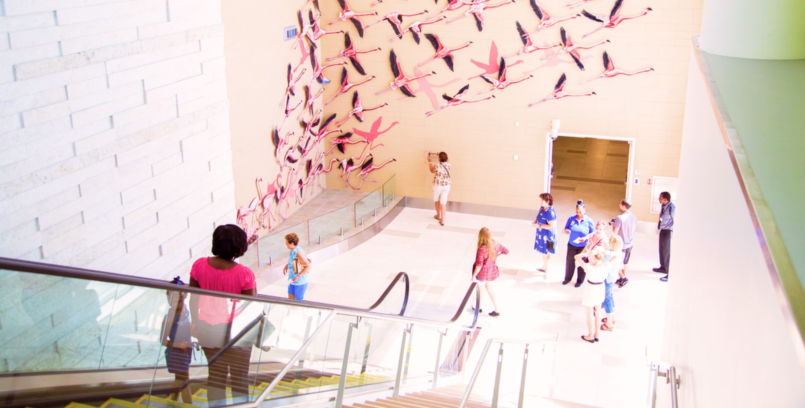 Escalator to lobby with flamingo wall art