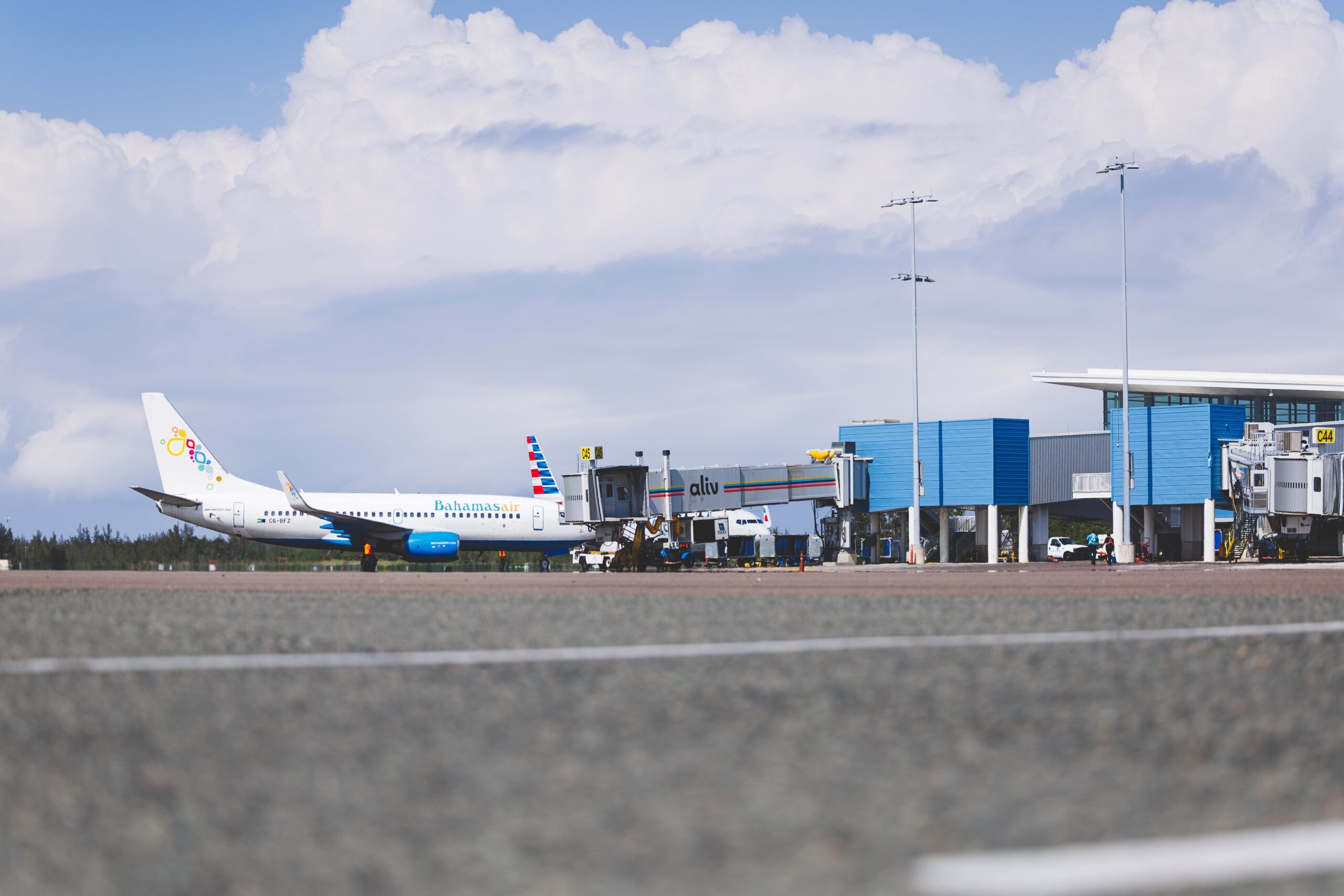 The LPIA runway with BahamasAir in front of a dock titled aliv.